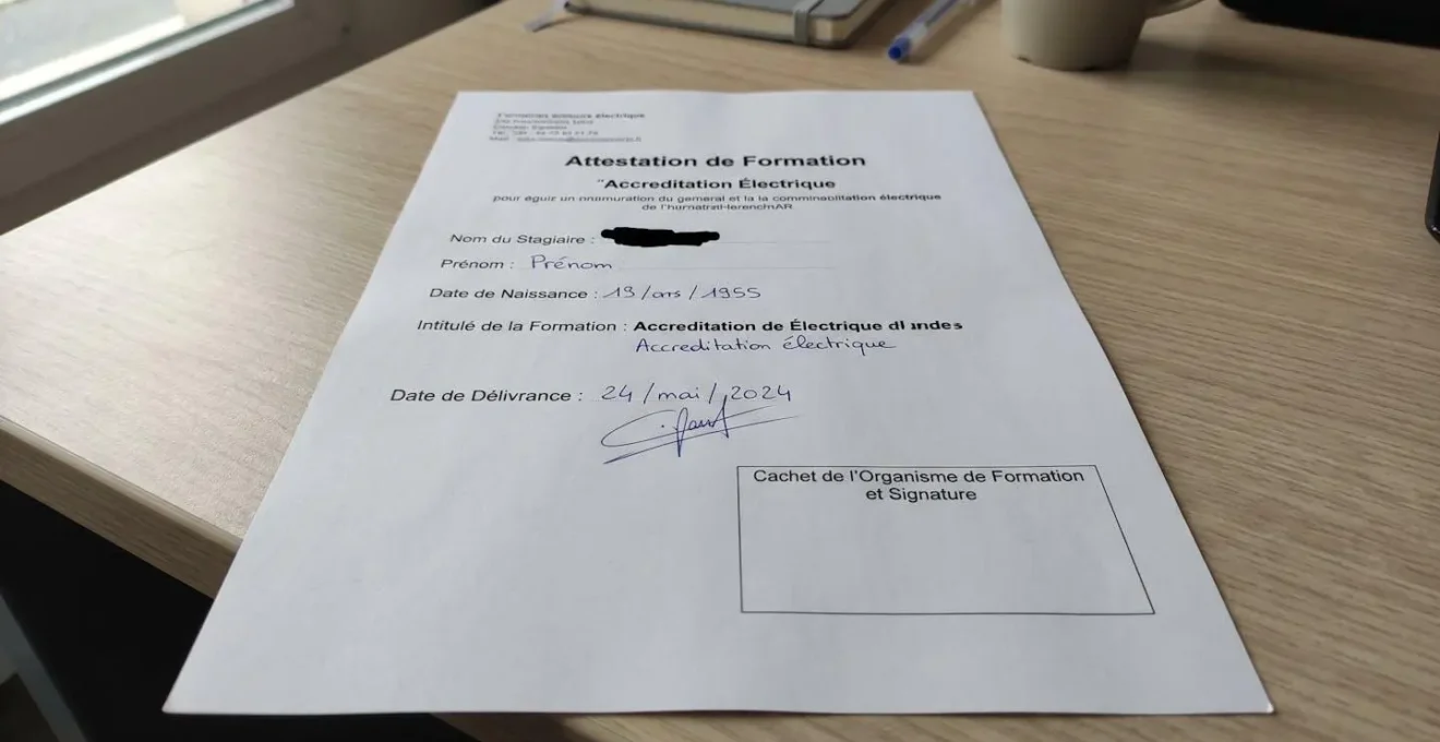 Gros plan sur un carnet d'habilitation électrique ouvert avec tampon officiel et signature manuscrite floutée, posé sur un bureau contemporain épuré
